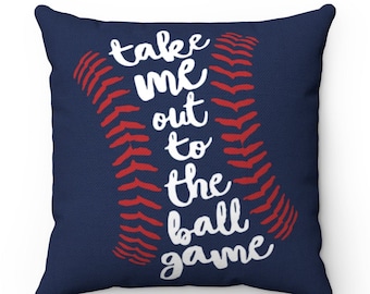 May include: A navy blue throw pillow with a white baseball graphic and the text "take me out to the ball game".