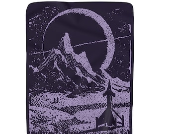 May include: A dark purple blanket with a light purple graphic print. The print depicts a mountain range, a large circle, and a stylized structure. The blanket has a soft, textured appearance.
