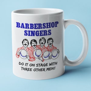 Puede incluir: Taza de cerámica blanca con un diseño azul y rojo. La taza presenta una imagen de dibujos animados de cuatro hombres con camisas y sombreros a rayas rojas y blancas, cantando. El texto "BARBERSHOP SINGERS" está en letras azules sobre la imagen. Debajo de la imagen, el texto "DO IT ON STAGE WITH THREE OTHER MEN!" está en letras azules.