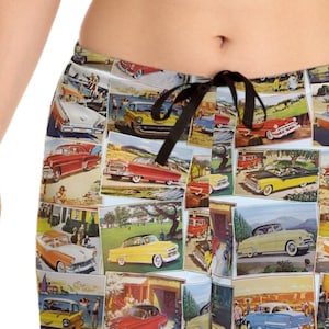 Puede incluir: Pantalones de pijama azul y blanco con un estampado de coches antiguos. El estampado presenta una variedad de coches de diferentes colores y estilos, todos sobre un fondo azul claro.