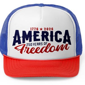 Könnte beinhalten: Eine patriotische Trucker-Mütze mit weißer Front, rotem Schirm und blauem Mesh-Rücken. Die Mütze trägt den Text "AMERICA" in Marineblau, mit "250 YEARS OF Freedom" in roter Schrift und den Jahreszahlen "1776 2026".