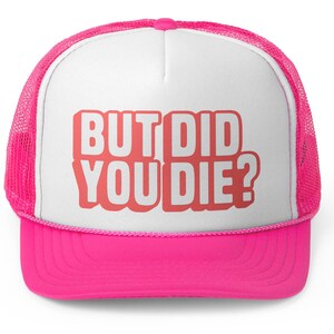 Op de afbeelding: Een felroze truckerpet met een wit voorpaneel en een roze mesh achterkant. De pet heeft de tekst "BUT DID YOU DIE?" in vette, koraalkleurige letters. De klep is effen felroze.
