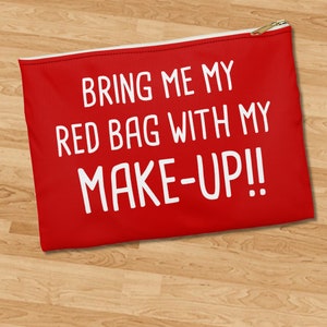 May include: Red zippered pouch with white text that reads "Bring me my red bag with my make-up!!"
