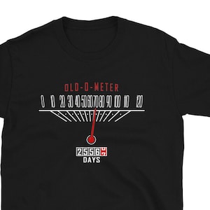 May include: Black t-shirt with a white graphic of a speedometer labeled "OLD-O-METER" with a red needle pointing to 2556, which is labeled "DAYS".