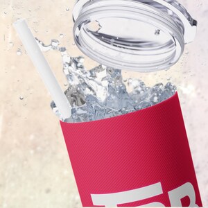 May include: A pink reusable tumbler with a white straw and a clear lid. The tumbler is filled with water and ice.