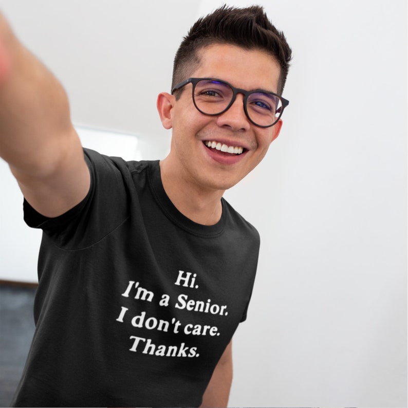 May include: A black t-shirt with white text that reads "Hi. I'm a Senior. I don't care. Thanks."