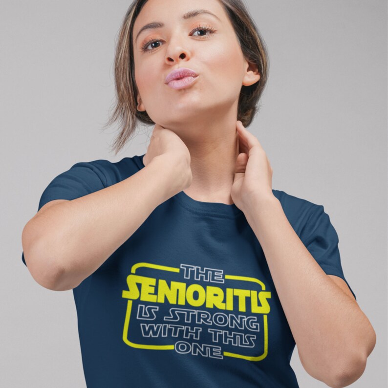 May include: A navy blue t-shirt with a yellow graphic that says "The Senioritis Is Strong With This One".