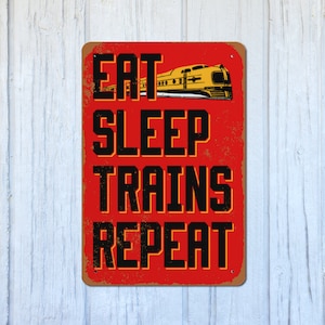 May include: Red metal sign with distressed texture featuring a yellow train and the text "Eat Sleep Trains Repeat".