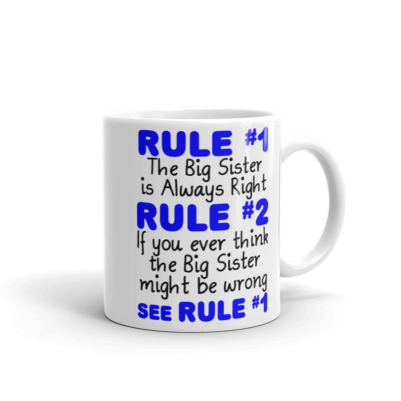 May include: White ceramic mug with blue text that reads "RULE #1 The Big Sister is Always Right RULE #2 If you ever think the Big Sister might be wrong SEE RULE #1"