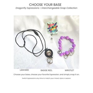 Puede incluir: Un cordón negro con un broche circular, un portacredenciales cuadrado con un gráfico colorido de libélula y mariposas, y una pulsera de cuentas moradas con un broche metálico, etiquetado CHOOSE YOUR BASE Dragonfly Expressions.
