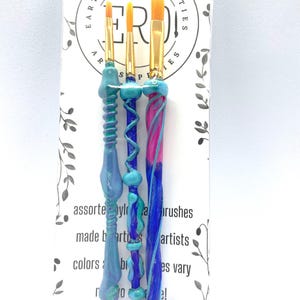 May include: Set of three paint brushes with colorful, textured handles. The brushes are made with assorted nylon and are made by artists for artists. The colors and brush sizes vary.