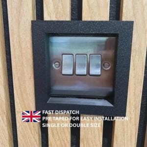 May include: A triple light switch with a metallic silver finish mounted within a square black frame. The switch is set against a wall paneling background featuring vertical light wood slats separated by thin black felt-like strips.