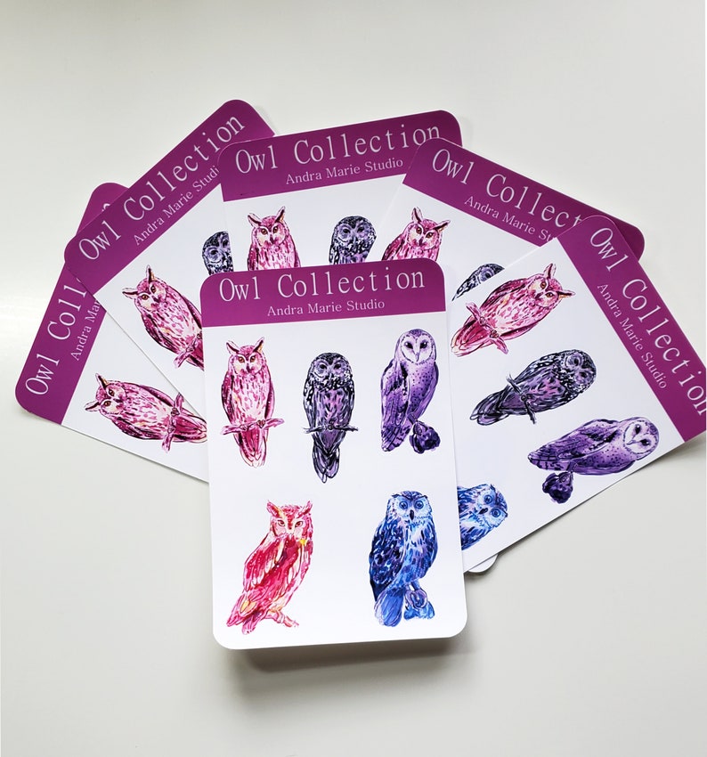 May include: A set of six cards featuring watercolor illustrations of owls. Each card has the text "Owl Collection" and "Andra Marie Studio" printed on it. The owls are depicted in shades of purple, pink, and blue.