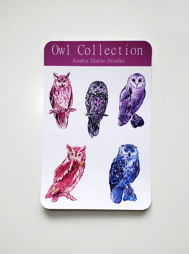 May include: A set of five watercolor owl stickers featuring different owl poses and color combinations. The stickers are on a white background with the text "Owl Collection" and "Andra Marie Studio" in purple.