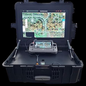 May include: A black, ruggedized case with a large screen displaying a map. A smaller handheld device with a screen is connected to the larger screen. The case is open, revealing the internal components and the screens. The screens display a detailed aerial view of a residential area.