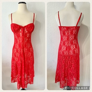 May include: A red lace slip dress with a sweetheart neckline and adjustable straps. The dress is sheer and has a floral pattern.
