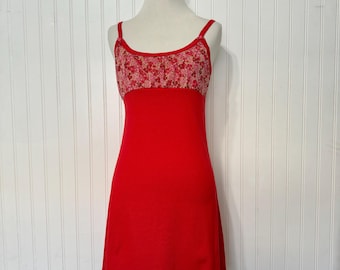 May include: A red sleeveless dress with a floral print on the bodice and a scalloped hem.