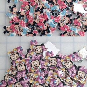 May include: A large pile of colorful cartoon character embellishments featuring Mickey Mouse and Minnie Mouse. The embellishments are made of plastic and have a glossy finish.