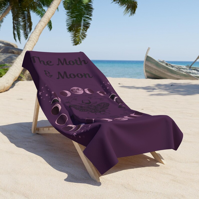 The image is a purple towel with a design featuring a butterfly and the phases of the moon.