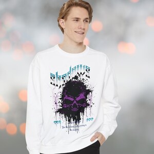 a young man wearing a white sweatshirt with a purple skull on it