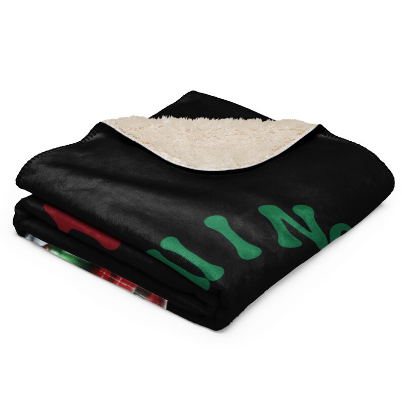 a black blanket with a green and red design on it