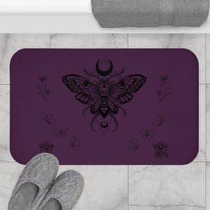 a purple towel with a butterfly design and the text "The Moth & Moon" printed on it, along with a pair of flip-flops and a blue cooler.