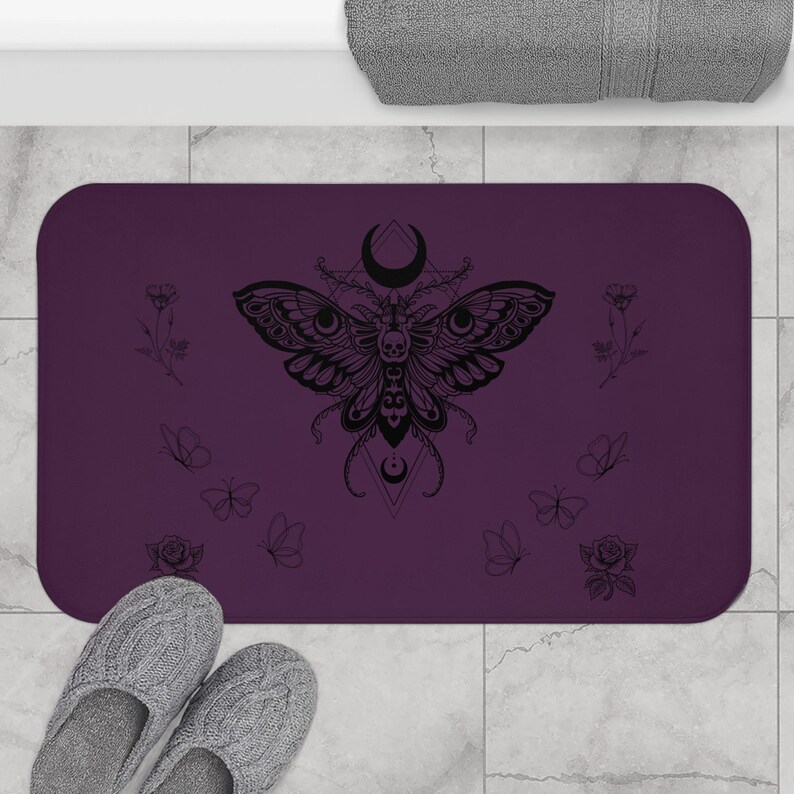 a purple towel with a butterfly design and the text "The Moth & Moon" printed on it, along with a pair of flip-flops and a blue cooler.