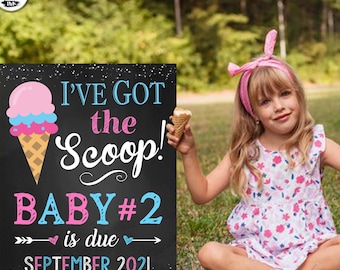 May include: A chalkboard sign with a pink and blue ice cream cone graphic announces "I've Got the Scoop! Baby #2 is due September 2021".
