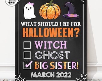 May include: A Halloween-themed chalkboard sign with a ghost, pumpkin, and witch hat illustration. The sign asks "WHAT SHOULD I BE FOR HALLOWEEN?" with options for Witch, Ghost, and Big Sister! The checked option is Big Sister! and the date is March 2022.