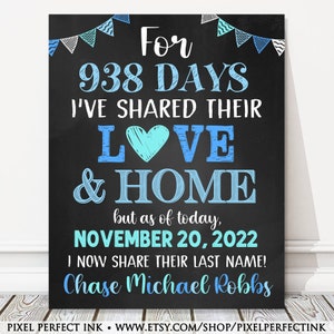 May include: A chalkboard sign with blue and white decorations announcing a wedding. The sign reads "For 938 days I've shared their love & home, but as of today, November 20, 2022 I now share their last name! Chase Michael Robbs".