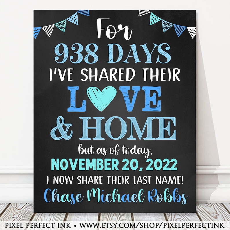 May include: A chalkboard sign with blue and white decorations announcing a wedding. The sign reads "For 938 days I've shared their love & home, but as of today, November 20, 2022 I now share their last name! Chase Michael Robbs".