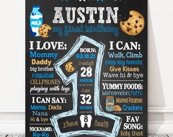 May include: A blue and black chalkboard style first birthday sign for a boy named Austin. The sign includes details about his birthdate, weight, height, and favorite foods. It also includes a list of things he loves and can do. The sign features a cartoon milk bottle, cookies, and a tooth.