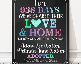 May include: A chalkboard sign with colorful text announcing an adoption. The text reads "For 938 days we've shared their love & home, but now we share their last name! Adam Lee Walter Melinda Anne Walter Adopted: November 8, 2022".