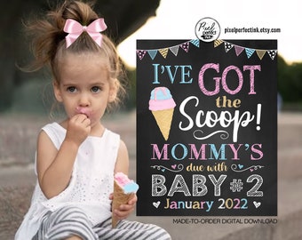 May include: A chalkboard sign with the text "I've Got the Scoop! Mommy's due with Baby #2 January 2022" and a pink and blue ice cream cone graphic.