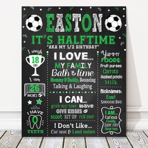 May include: Black chalkboard sign with green and white text and graphics. The sign says "Easton It's Halftime" and includes details about the child's age, weight, height, favorite foods, and personality. The sign is decorated with soccer balls.