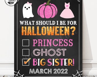 May include: Black chalkboard-style sign with white border and spiderweb accents. The sign features a ghost, pink glitter pumpkin, and a pink dress illustration. Text reads "WHAT SHOULD I BE FOR HALLOWEEN?" with options for Princess, Ghost, and Big Sister, marked with a check. "MARCH 2022" is also displayed.
