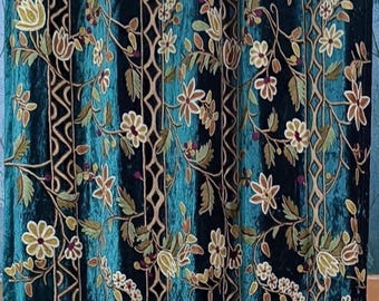 May include: Teal velvet curtains with an embroidered floral design. The curtains feature a repeating pattern of flowers, leaves, and geometric shapes in shades of cream, brown, and green. The fabric has a vertical striped texture.