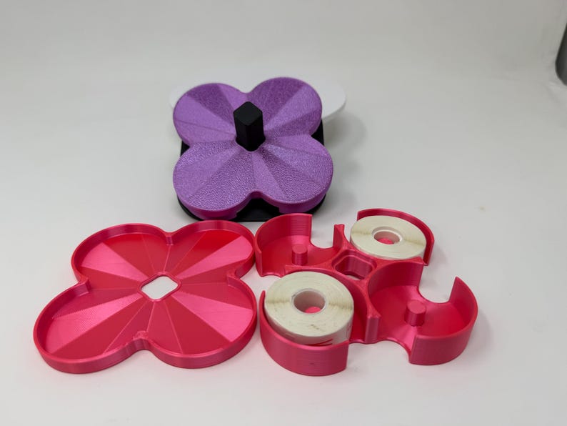 Pode incluir: Um conjunto de organizadores de secret&aacute;ria em forma de trevo, em tons de rosa e roxo. O conjunto inclui uma bandeja, um dispensador de fita adesiva com dois rolos e um porta-canetas. Os artigos s&atilde;o feitos de pl&aacute;stico.