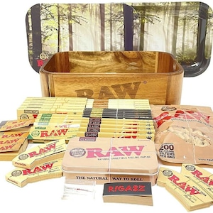 May include: A wooden box with the word "RAW" printed on the front, filled with various RAW rolling papers, tips, and filters. The box is sitting on a wooden tray with a forest scene printed on it.