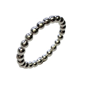 Könnte beinhalten: Ein silberner Perlenring mit schlichtem Design. Der Ring besteht aus kleinen, runden Perlen, die gleichmäßig verteilt sind.