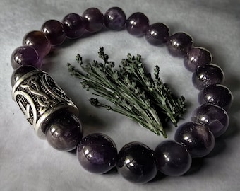 May include: A dark purple amethyst gemstone bracelet with a silver charm featuring a Celtic knot design.