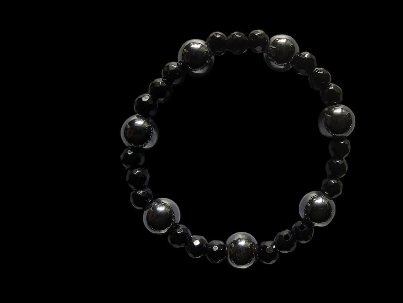 Op de afbeelding: Een zwarte kralen armband met afwisselende zwarte en zilveren ronde kralen.