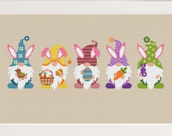 May include: Five colorful gnomes with bunny ears holding Easter-themed items. The gnomes are wearing blue, yellow, pink, purple, and green hats. They are holding a bird, a basket of eggs, an egg, a carrot, and a bunny.