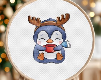 May include: A blue penguin wearing a brown and white reindeer hat and a blue scarf, holding a red mug. The penguin is smiling and has a cute, cartoon-like appearance.