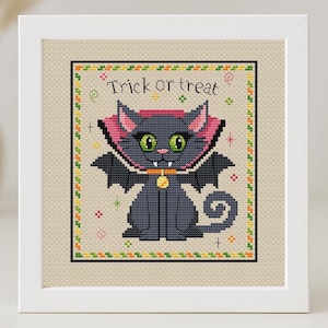 May include: Cross stitch pattern featuring a black cat with pink bat wings and a collar, wearing a pink cape. The cat has green eyes and fangs. The text "Trick or treat" is above the cat.