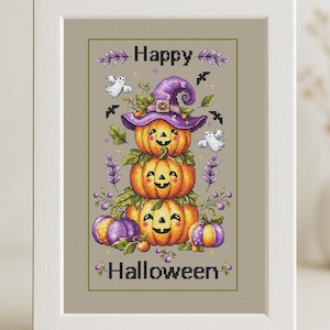 May include: Cross-stitch artwork showing three orange pumpkins stacked, each with a smiling face, and a purple witch's hat. The words "Happy Halloween" are stitched above and below, with ghosts and bats.