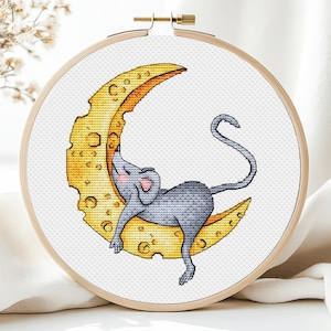 May include: A gray mouse sleeping on a crescent moon shaped piece of cheese. The cheese is yellow and has holes in it.