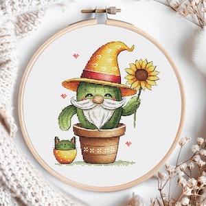 Puede incluir: Un cactus verde con un sombrero amarillo y rojo con barba blanca y sosteniendo un girasol amarillo. Un pequeño gato naranja está sentado en una maceta al lado del cactus.