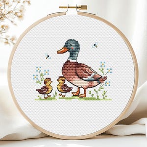 Op de afbeelding: Een set van drie keramische mokken met een gespikkelde, matte afwerking. De mokken zijn in crème, lichtgrijs en donkergrijs. Elke mok heeft een eenvoudig, minimalistisch ontwerp.