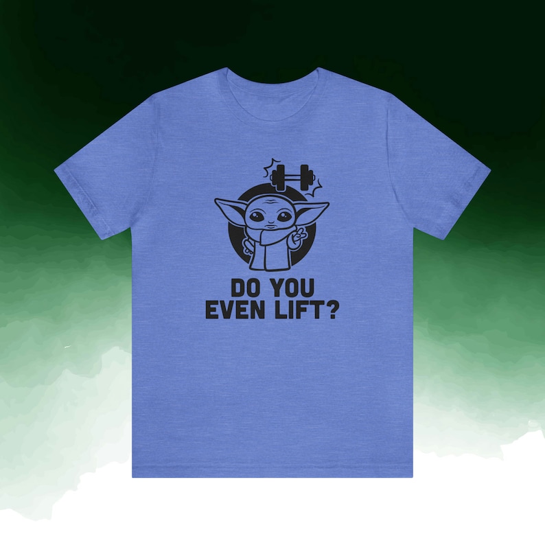K&ouml;nnte beinhalten: Hellblaues T-Shirt mit einer schwarzen Grafik eines Zeichentrickcharakters und dem Text "DO YOU EVEN LIFT?". Die Figur befindet sich in einem schwarzen Kreis mit einer Hantel &uuml;ber dem Kopf.